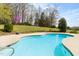 Private pool surrounded by a green lawn and mature trees at 500 Walnut Hill Dr, Hillsborough, NC 27278