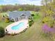 Aerial view of the kidney bean-shaped pool and large backyard with lush green lawn and landscaping at 500 Walnut Hill Dr, Hillsborough, NC 27278