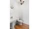 Simple powder room featuring a pedestal sink, toilet, hardwood floors, and a chandelier at 500 Walnut Hill Dr, Hillsborough, NC 27278