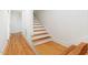 Staircase featuring hardwood steps, white risers, and hardwood floors in the hallway at 500 Walnut Hill Dr, Hillsborough, NC 27278