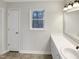 Clean bathroom featuring white vanity, a window, and neutral floor tiles at 5005 Baywood Forest Dr, Knightdale, NC 27545