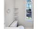 Bright bathroom with white fixtures, corner shelves, and a window offering neighborhood views at 5005 Baywood Forest Dr, Knightdale, NC 27545