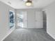 Spacious bedroom featuring plush gray carpeting, modern ceiling fan, and a sunlit window at 5005 Baywood Forest Dr, Knightdale, NC 27545
