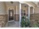 Inviting front porch with stone accents, a brown door, and manicured landscaping creates curb appeal at 5033 Homeplace Dr, Apex, NC 27539