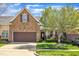 Charming townhome with stone accents, a brown garage door, manicured lawn and inviting curb appeal at 5033 Homeplace Dr, Apex, NC 27539