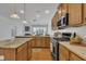 Bright kitchen featuring hardwood floors, wooden cabinets, stainless steel appliances, and a view to the living space at 5033 Homeplace Dr, Apex, NC 27539