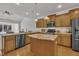Well-equipped kitchen with wooden cabinets, stainless steel appliances, a kitchen island, and great lighting at 5033 Homeplace Dr, Apex, NC 27539