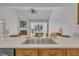 Modern kitchen features a stainless steel sink, hardwood floors, and a view of the living room with a fireplace at 5033 Homeplace Dr, Apex, NC 27539