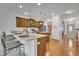 Open kitchen with hardwood floors, wooden cabinets, stainless steel appliances, and an island with seating at 5033 Homeplace Dr, Apex, NC 27539
