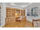Well-lit office features custom built-ins, hardwood floors, and a window providing natural light for productivity at 5033 Homeplace Dr, Apex, NC 27539