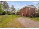 Brick two-story home featuring a long gravel driveway and fenced backyard at 506 N Harrison Ave, Cary, NC 27513