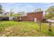 Backyard of brick two-story home featuring a wood deck and chain link fence at 506 N Harrison Ave, Cary, NC 27513