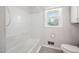 Bright bathroom featuring a bathtub, window, toilet, and white tile in shower at 506 N Harrison Ave, Cary, NC 27513
