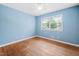 Bedroom featuring hardwood floors, a bright window, and light blue walls at 506 N Harrison Ave, Cary, NC 27513