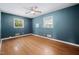 Bedroom with hardwood floors, two bright windows, and a ceiling fan at 506 N Harrison Ave, Cary, NC 27513