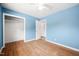 Light blue bedroom features hardwood floors, closet, and ceiling fan at 506 N Harrison Ave, Cary, NC 27513