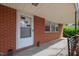 View of the home's covered front porch, featuring brick facade and a white front door at 506 N Harrison Ave, Cary, NC 27513