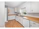 Well-lit kitchen featuring white appliances, light wood countertops, and white cabinetry at 506 N Harrison Ave, Cary, NC 27513