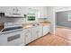Functional kitchen featuring white appliances, light wood countertops, and ample cabinetry at 506 N Harrison Ave, Cary, NC 27513