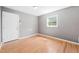 View of a gray room featuring a white door, a window, and light wood flooring at 506 N Harrison Ave, Cary, NC 27513