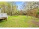 Expansive backyard featuring a mix of lush lawn and mature trees, partially fenced at 516 Edinburgh Dr, Burlington, NC 27215