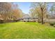 A sprawling backyard with lush lawn, mature trees, and a view of the home's rear exterior at 516 Edinburgh Dr, Burlington, NC 27215