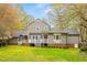 Exterior view of home with large backyard with mature trees and an expansive lawn at 516 Edinburgh Dr, Burlington, NC 27215