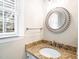 Stylish bathroom featuring a granite countertop, decorative mirror, and natural light at 516 Edinburgh Dr, Burlington, NC 27215