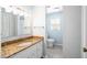 Bright bathroom featuring granite countertops, a large mirror, and a toilet in a separated space at 516 Edinburgh Dr, Burlington, NC 27215