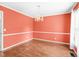 The dining room features a chandelier and is freshly painted with hardwood floors at 516 Edinburgh Dr, Burlington, NC 27215