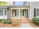 Inviting front porch with brick steps, black shutters, and colorful landscaping at 516 Edinburgh Dr, Burlington, NC 27215