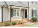Welcoming front porch with black door, black shutters, and beautiful landscaping at 516 Edinburgh Dr, Burlington, NC 27215