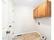 Functional laundry room with tile flooring, overhead cabinets, and convenient access to utilities at 516 Edinburgh Dr, Burlington, NC 27215