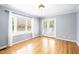 Bright living room features hardwood floors, large bay window, and double doors to the outdoors at 516 Edinburgh Dr, Burlington, NC 27215