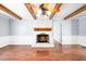 Bright living room featuring a white brick fireplace, wood beams and wood floors at 516 Edinburgh Dr, Burlington, NC 27215