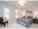 This bedroom features gray decor, two windows with a chair in front of one, and wall art at 5209 Rivington Rd, Fuquay Varina, NC 27526