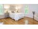 Light-filled bedroom with hardwood floors and two windows at 5209 Rivington Rd, Fuquay Varina, NC 27526