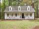 Charming home with inviting front porch, rocking chairs, and well-maintained yard in a wooded setting at 5209 Rivington Rd, Fuquay Varina, NC 27526