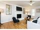 Bright living room with a fireplace, hardwood floors, ceiling fan, and stylish decor creating an inviting atmosphere at 5209 Rivington Rd, Fuquay Varina, NC 27526