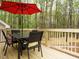Cozy outdoor patio with a black dining table, chairs, and a red umbrella at 5209 Rivington Rd, Fuquay Varina, NC 27526