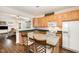 Modern kitchen featuring wood cabinets, an island with seating, and an open layout to the living area at 5551 Vista View Ct, Raleigh, NC 27612