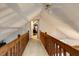 Hallway with wood railing overlooking a living space below and leading to a bedroom at 5578 Tabbs Creek Church Rd, Oxford, NC 27565