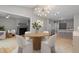 Dining area with a chandelier, adjacent to a modern kitchen with bar stool seating at 58 Stoneridge Rd, Durham, NC 27705
