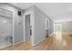 Hallway with hardwood floors leading to a bathroom and entrance to the living space at 58 Stoneridge Rd, Durham, NC 27705
