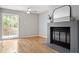 Living room featuring a fireplace, a fan, hardwood floors, and large window views at 58 Stoneridge Rd, Durham, NC 27705