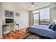 Bright bedroom with balcony, hardwood floors, desk, and comfortable chair, perfect for relaxing or working at 601 W Rosemary St # 418, Chapel Hill, NC 27516