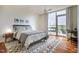 Bright bedroom featuring a ceiling fan, patterned rug, and balcony access with outdoor seating at 601 W Rosemary St # 418, Chapel Hill, NC 27516