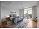 Bright bedroom with hardwood floors, a modern rug, access to balcony, and a ceiling fan at 601 W Rosemary St # 418, Chapel Hill, NC 27516