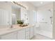 Bright bathroom featuring double sinks, white cabinets, and a tiled walk-in shower with a built-in seat at 605 Lakeview Ave, Wake Forest, NC 27587