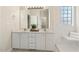 Bathroom vanity with double sinks, large mirror, and a tiled walk-in shower with a built-in seat at 605 Lakeview Ave, Wake Forest, NC 27587